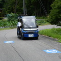 市道を走る「奥永源寺けい流カー」。道路上の黒い線が自動運転を制御するために敷設された電磁誘導線