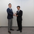 米澤チーフエンジニアにトロフィーを手渡す三浦選考委員長（左）