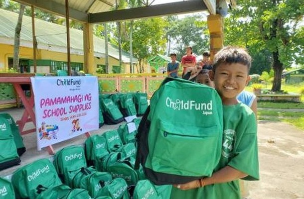 学用品を受け取り、笑顔を見せるフィリピンの子ども