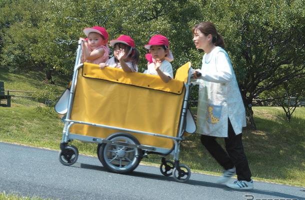 複数の子供が乗っていているカートを、坂道でも楽に操作できる「電動アシストお散歩カー」