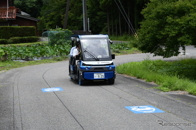 市道を走る「奥永源寺けい流カー」。道路上の黒い線が自動運転を制御するために敷設された電磁誘導線