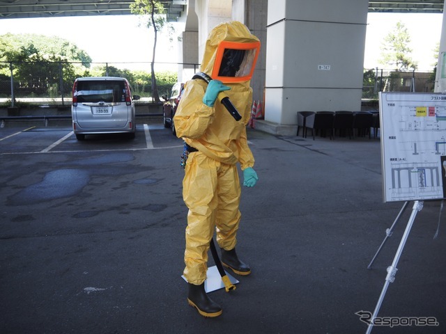下地処理では、研削材を空気圧で吹き付け、古い塗膜やサビを削り落とす。その際の防護服